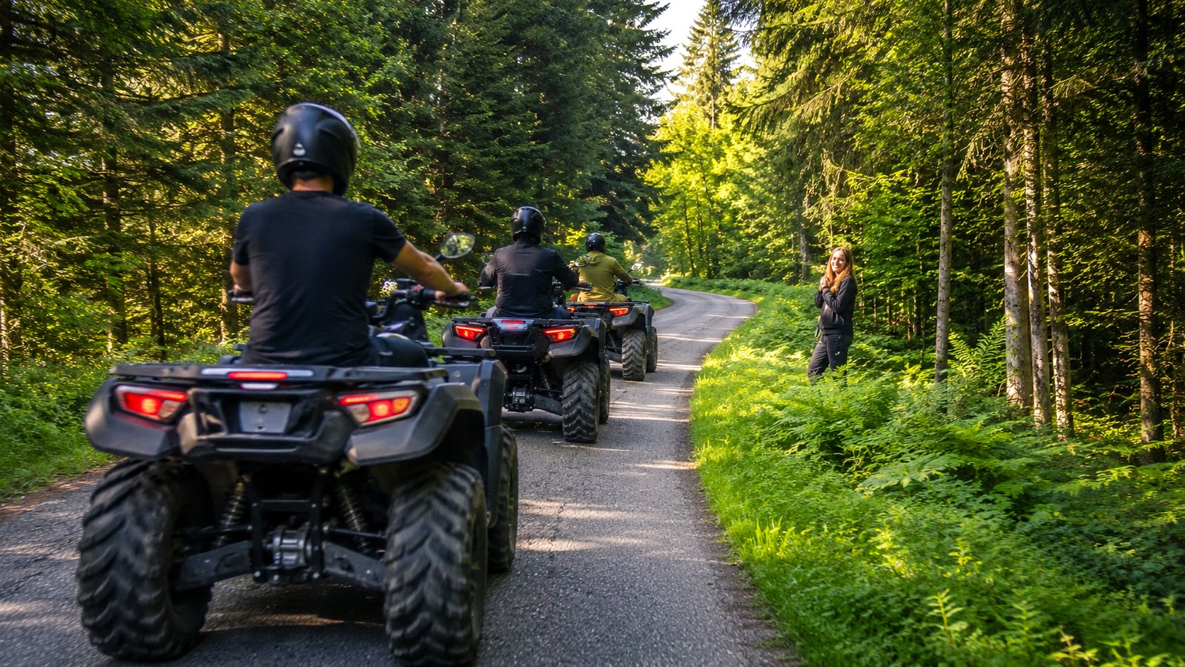 Convoi de quads et UTV sur une route en forêt en lumière naturelle